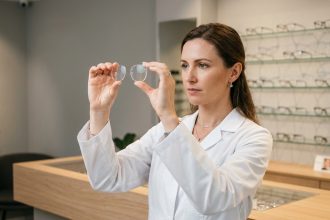 Opticienne professionnelle examinant des verres de lunettes de haute qualité dans une boutique d'optique moderne