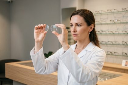 Opticienne professionnelle examinant des verres de lunettes de haute qualité dans une boutique d'optique moderne